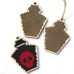 May include: Three wooden ornaments shaped like lanterns. One lantern has a black and red skull design, while the other two are blank.