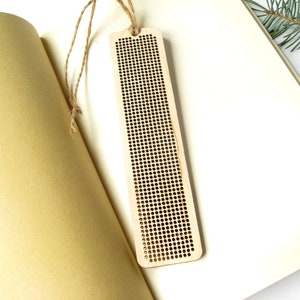 Peut inclure: Un marque-page en bois avec un motif quadrill&eacute; pour la broderie au point de croix. Le marque-page est brun clair et a une ficelle attach&eacute;e au sommet.