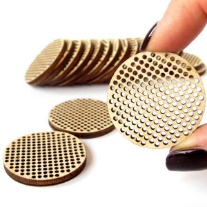May include: A stack of round wooden embroidery hoops with a grid pattern. The hoops are approximately 2 inches in diameter.