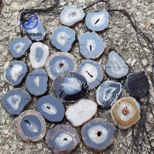 Puede incluir: Una colección de 18 rebanadas de ágata con patrones en blanco y negro. Las rebanadas tienen un diámetro de aproximadamente 5 cm y un acabado natural y pulido.