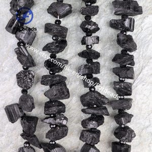 May include: Strands of rough-cut black tourmaline beads. The beads are irregularly shaped and strung together with small, faceted black beads. The image includes the text "Forbeads" and a website address.