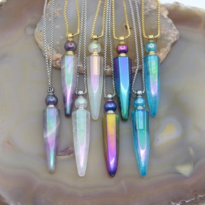 May include: Eight iridescent glass bottle pendants on silver chains. The bottles are in various colors, including purple, blue, green, and white. Each bottle has a small silver cap and a black bead at the top of the chain.