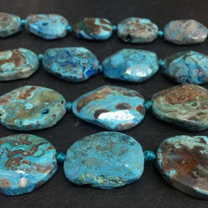 May include: A strand of blue and brown agate gemstone beads. The beads are oval shaped and have a natural, polished finish.