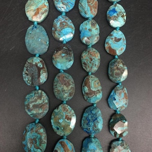 May include: A strand of turquoise and brown agate gemstone beads. The beads are oval shaped and have a natural, polished finish.