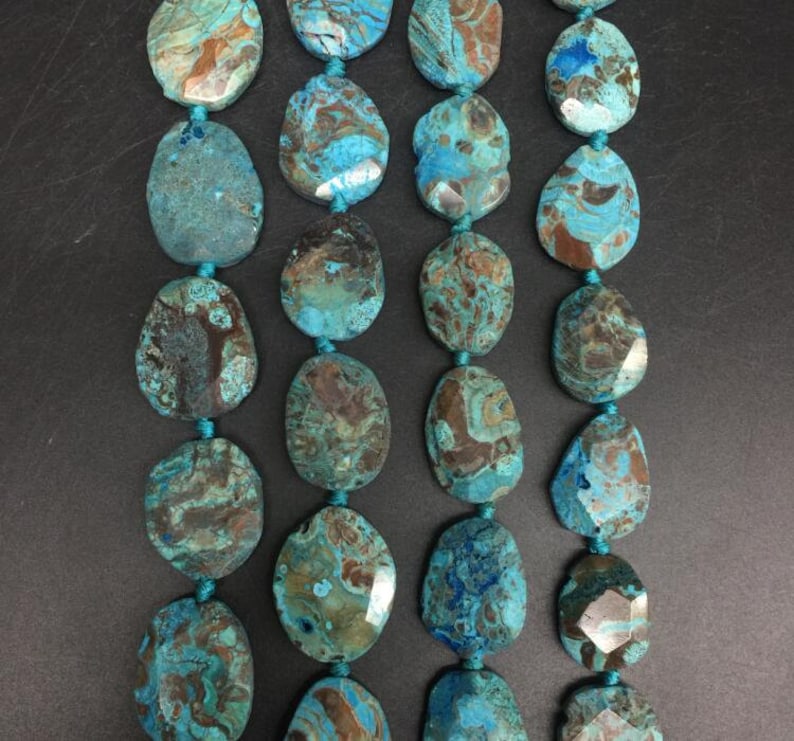 May include: A strand of turquoise and brown agate gemstone beads. The beads are oval shaped and have a natural, polished finish.