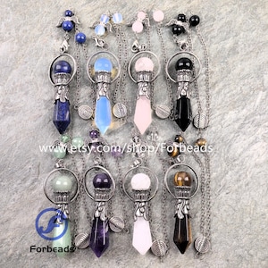 Peut inclure: Huit pendules en cristal avec des capuchons et des chaînes en métal argenté. Les pierres incluent bleu, bleu clair, rose, noir, vert, violet, blanc et œil-de-tigre brun. Chaque pièce comporte une petite breloque aile et une perle ronde.