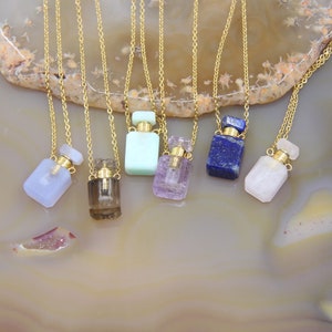 May include: Seven gold chain necklaces with crystal perfume bottle pendants. The bottles are made of various semi-precious stones, including amethyst, agate, clear quartz, smoky quartz, lapis lazuli, and green aventurine.