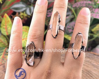 May include: Three rings with light brown crystal stones. The rings have a dark metal band and a textured setting around the crystals. The rings are displayed on a hand. The Etsy shop name "Forbeads" is visible.