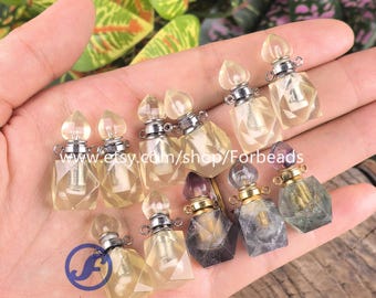 Puede incluir: Una colección de pequeños colgantes con forma de frasco de perfume facetado, hechos de piedra translúcida. Cada frasco cuenta con una tapa metálica con una pequeña anilla para colgar. Las piedras varían en color, incluyendo tonos amarillo pálido, gris humo y morado.