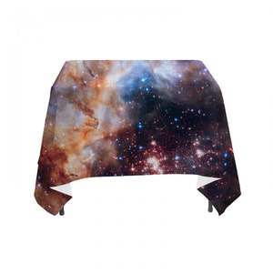 May include: A rectangular tablecloth with a colorful nebula pattern. The tablecloth features a dark blue background with swirling orange, red, and white clouds. The nebula is dotted with thousands of tiny white stars.