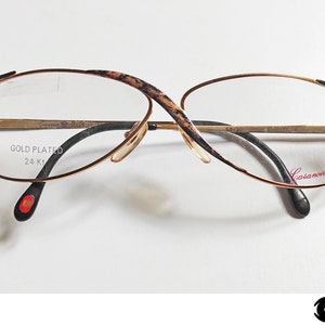 Puede incluir: Gafas chapadas en oro con montura de carey y el texto "GOLD PLATED 24 Kt" y "Casanova Ricerca" en las patillas.