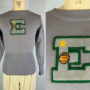 May include: Gray sweater with a green and gray felt letter E with a yellow star and a basketball on it.