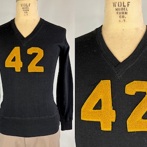 May include: Black long-sleeved jersey with a v-neck and the number 42 in gold felt on the front. The jersey is made by Wolf Model Form Co. N.Y.