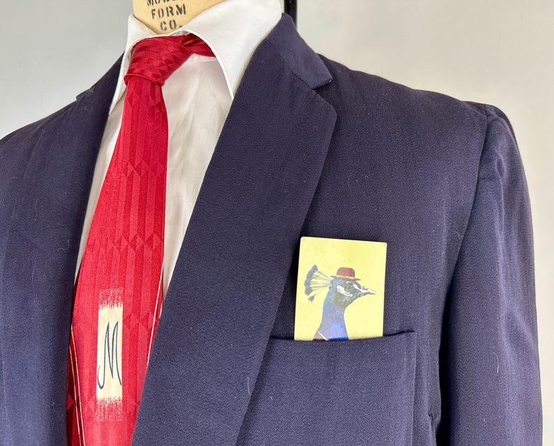 May include: A white ceramic mug with a black handle and the text "But First, Coffee" in a black, bold font. The mug is sitting on a white surface. The mug is approximately 4 inches tall.