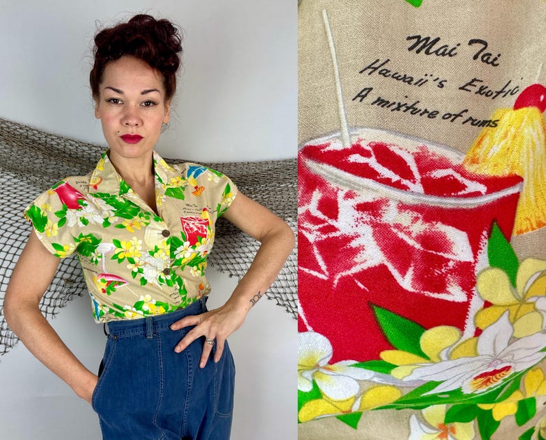 May include: Tan short-sleeved button-up shirt with a tropical print featuring a cocktail, flowers, and flamingos. The shirt has a collared neckline and wooden buttons. The text on the shirt reads "Mai Tai Hawaii's Exotic A mixture of rums."