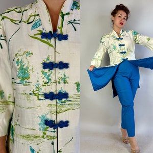 Puede incluir: Una chaqueta blanca de manga larga, abotonada, con estampado floral y botones azules. La chaqueta tiene un cuello mandarín y una falda larga y fluida. La chaqueta se combina con pantalones azules.