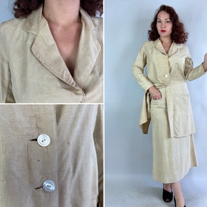 May include: A beige linen suit with a long jacket and a skirt. The jacket has a collar, long sleeves, and two buttons. The skirt is knee-length and has a straight silhouette.