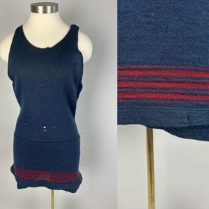 Könnte beinhalten: Ein marineblaues ärmelloses Tanktop mit roten Streifen am Saum. Das Tanktop ist aus weichem, gestricktem Stoff.