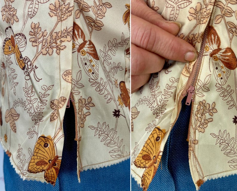 May include: Close-up of a cream-colored garment with a brown butterfly and floral pattern. The garment has a zipper closure and is made of a light fabric. The design includes detailed illustrations of butterflies and foliage.