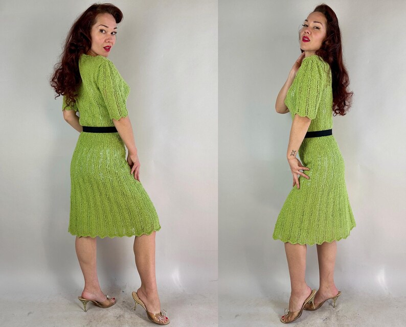 May include: A vintage lime green knit dress with short sleeves and a knee-length skirt. The dress features a black belt at the waist. The model is wearing gold-colored heels.