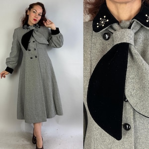 May include: A grey wool coat with a black velvet collar and bow. The collar is embellished with black rhinestones. The coat has a double-breasted closure and long sleeves.