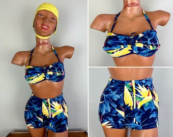 May include: A blue and yellow floral print swimsuit with a halter top and high-waisted bottoms. The swimsuit is on a mannequin with a yellow swim cap.