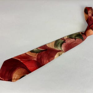 May include: A red, brown, and green patterned tie with a swirl design.