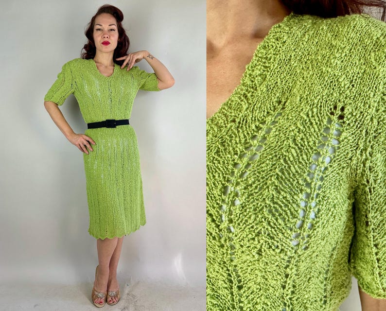 May include: A lime green knitted dress with short sleeves and a V-neck. The dress is cinched at the waist with a black belt. The dress has a textured, open weave design and falls to the mid-calf. The dress is a vintage style.