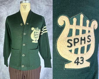 Cardigã Verde Inveja dos Anos 40 | Suéter universitário vintage em lã verde-floresta dos anos 40 com detalhes em listras brancas e cinto falso nas costas | Tamanho Pequeno