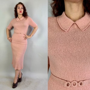 May include: A pink knitted dress with a collared neckline and a matching skirt. The dress has a fitted bodice and a slightly flared skirt. The dress is made of a soft, lightweight knit fabric.