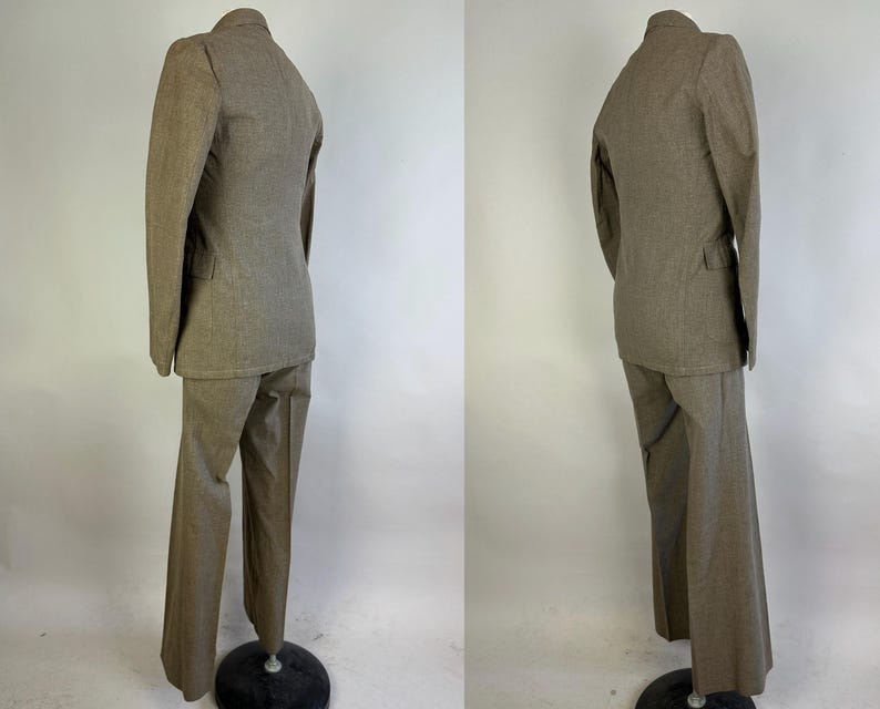 Op de afbeelding: Een tweedelig pak in een effen lichtbruine kleur, bestaande uit een blazer met lange mouwen en een ingekeepte revers, en een bijpassende broek van volledige lengte. Het pak wordt getoond op een etalagepop, met de rug- en zijaanzichten.