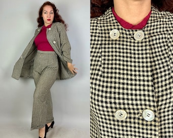 Könnte beinhalten: Ein zweiteiliger Vintage-Anzug mit einem schwarz-cremefarbenen Karomuster. Der Anzug besteht aus einer langärmligen Jacke mit großen, runden Knöpfen und einer passenden Hose mit weitem Bein. Ein bordeauxrotes Oberteil ist unter der Jacke zu sehen.