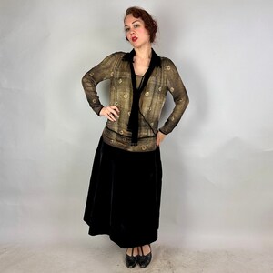 May include: A woman wearing a brown and gold patterned blouse with a black velvet skirt and black heels.