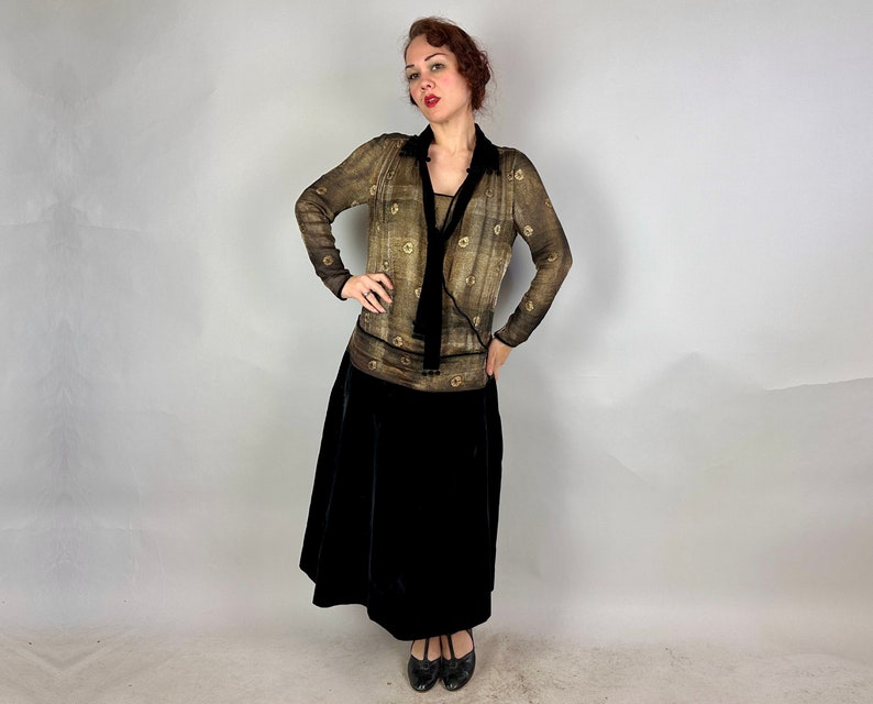 May include: A woman wearing a brown and gold patterned blouse with a black velvet skirt and black heels.