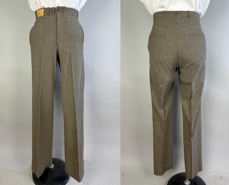 Op de afbeelding: Broek met hoge taille in een effen bruine kleur, voorzien van een rechte pijp, een knoop- en ritssluiting, riemlussen en een klein rechthoekig label in lederlook op de tailleband. De achterkant toont twee paspelzakken.