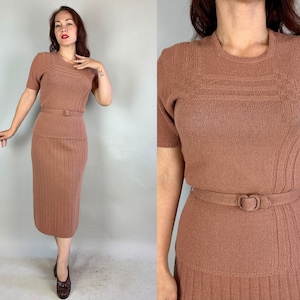 Puede incluir: Un conjunto de falda y suéter de punto marrón con textura acanalada. El conjunto presenta un escote redondo y mangas cortas. Se incluye un cinturón marrón.