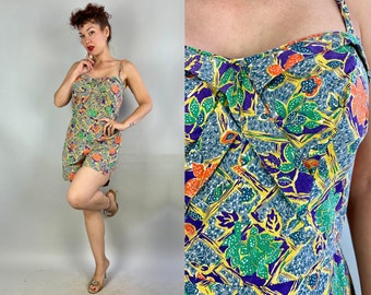 May include: A vintage-style swimsuit with a colorful floral print in shades of yellow, green, orange, and purple. The swimsuit has a halter-style neckline and a fitted bodice.
