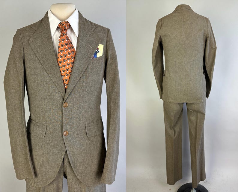 Op de afbeelding: Een beige tweedelig pak bestaande uit een colbert met twee knopen, inkepingen in de revers en klepzakken, gecombineerd met een bijpassende broek. Het colbert wordt gedragen over een wit overhemd met een oranje das met patroon en een pochet.