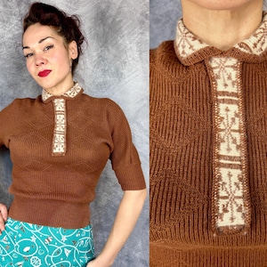 Pu&ograve; includere: Un top in maglia marrone con colletto e paramontura a fantasia bianca e beige. Il top a maniche corte ha una trama a coste e un motivo a rombi. Il colletto e la paramontura presentano un design geometrico.