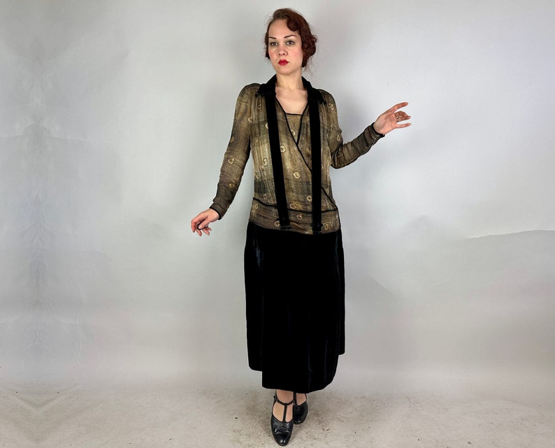 May include: A vintage-style dress with a black velvet skirt and a sheer, gold-toned top with a floral pattern. The top features a V-neckline and a wrap-style design.