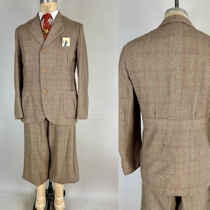 Könnte beinhalten: Ein Vintage-Anzug aus braunem Tweed mit Blazer und passenden Shorts. Der Blazer hat drei Holzknöpfe, ein Einstecktuch und eine rot gemusterte Krawatte. Der Anzug wird auf einer Schaufensterpuppe präsentiert.