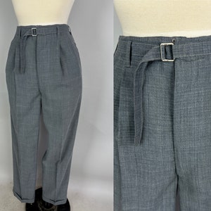 May include: Gray pleated pants with a belt and a silver buckle. The pants have a subtle checkered pattern.