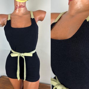 Pode incluir: Uma regata preta de malha sem mangas com decote quadrado e alças verde-claras. A peça inclui um cinto de tecido verde-claro a condizer na cintura, criando uma silhueta cintada com um tecido de malha canelada texturizada.