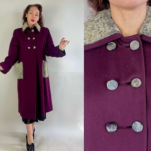 May include: A burgundy wool coat with a faux fur collar and pockets. The coat has a double breasted closure with silver buttons.