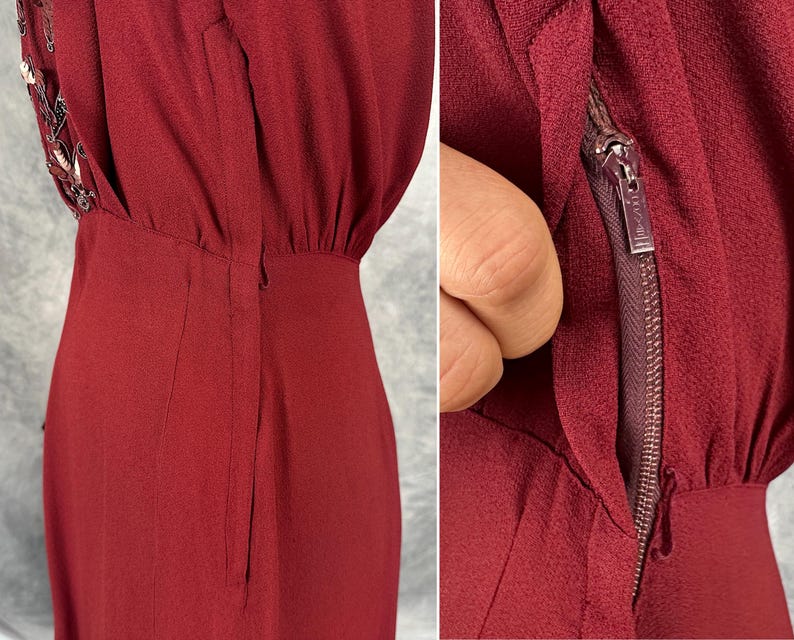May include: A close-up of a burgundy dress with a zipper detail. The dress has a fitted bodice and a slightly flared skirt. The zipper is visible on the side of the dress. The dress has a textured fabric and a subtle sheen.