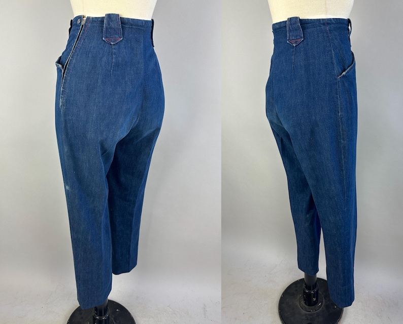 May include: High-waisted dark blue denim pants featuring a side zipper closure, a structured waistband with belt loops, and a tapered leg silhouette. The garment is shown from two angles, highlighting the side seam zipper and the back pocket placement.