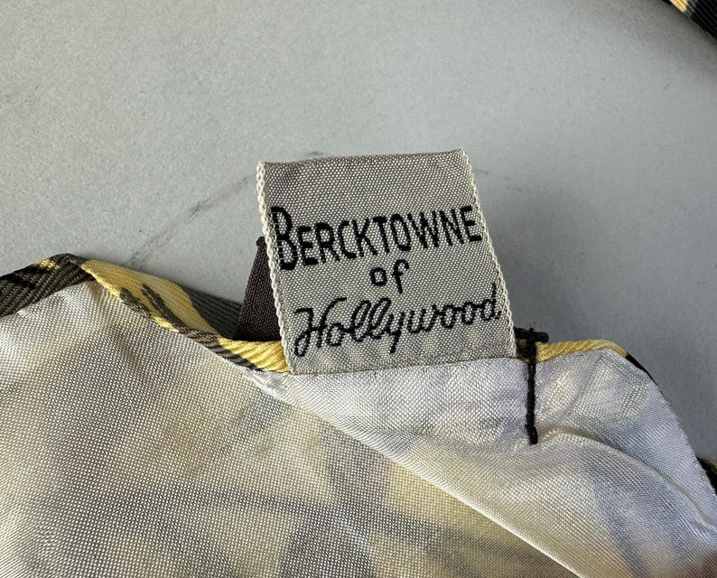 May include: A white fabric label with black text that reads "Bercktowne of Hollywood".