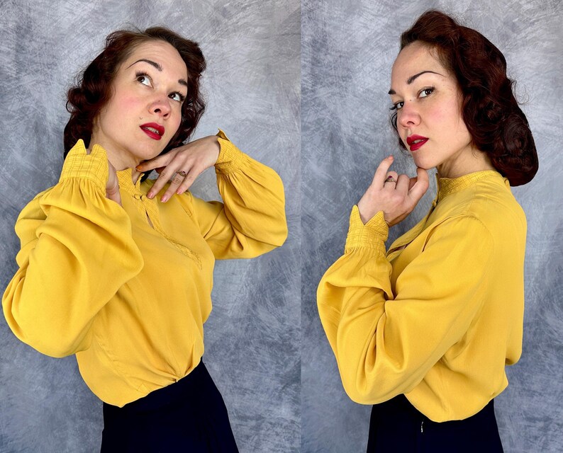 May include: A white ceramic mug with a black handle and the text "But First, Coffee" in a bold, black font. The mug is set against a blurred background, suggesting a cozy setting.