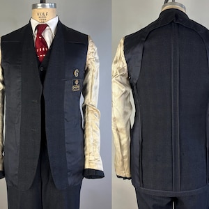 May include: A dark navy blue blazer shown from the front and back, featuring a partially unlined construction with visible beige interior lining on the sleeves and upper back. The front displays a dark vest, white shirt, and red patterned tie.
