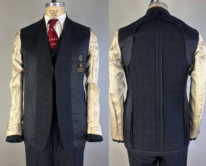 May include: A dark navy blue blazer shown from the front and back, featuring a partially unlined construction with visible beige interior lining on the sleeves and upper back. The front displays a dark vest, white shirt, and red patterned tie.